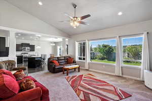 Living area featuring ceiling fan, decorative columns, light colored carpet, lofted ceiling, and recessed lighting