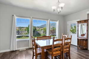 Dining room with a chandelier and dark wood-type flooring
