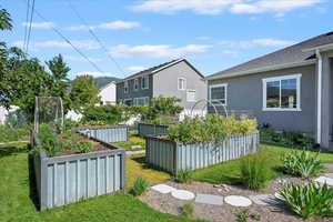 View of grassy yard featuring a vegetable garden