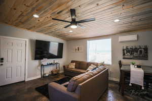 Living area with wooden ceiling, a wall mounted AC, ceiling fan, recessed lighting, and concrete flooring