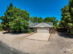Ranch-style home featuring driveway, an attached garage, and brick siding