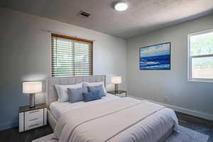Bedroom featuring dark wood-style floors and baseboards