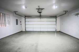 Garage featuring a garage door opener and electric panel