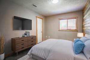 Bedroom featuring carpet and a textured ceiling