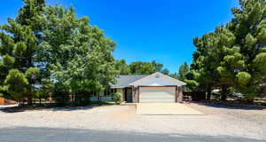 View of front of home featuring a garage, concrete driveway, and brick siding