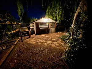 Yard at twilight with an outbuilding and an exterior structure