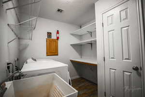 Laundry room featuring dark wood-style floors and washing machine and dryer