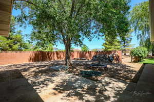 Fenced backyard with a fire pit and a patio