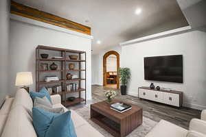 Living area with arched walkways, wood finished floors, and recessed lighting