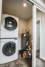 Laundry area with estacked washer and dryer, water heater, and recessed lighting