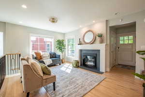 Living room with light wood finished floors, plenty of natural light, recessed lighting, and a fireplace
