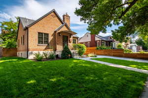 View of front of home featuring a chimney and brick siding