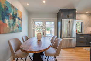 Dining space with healthy amount of natural light, light wood finished floors, french doors, and recessed lighting