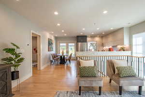 Living area with light wood-style floors and recessed lighting