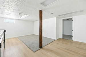 Basement featuring a textured ceiling and light wood finished floors