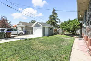View of yard with driveway, an outdoor structure, and a garage