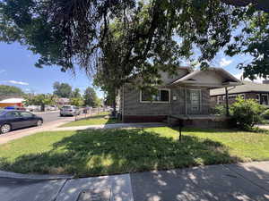 View of front of home with a front lawn, a porch, and brick siding