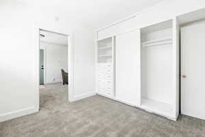 Unfurnished bedroom with carpet flooring and a closet
