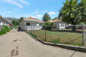View of front of house featuring a fenced front yard, concrete driveway, and a gate