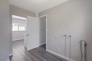 Washer and Dryer room with dark wood-style flooring and a textured ceiling