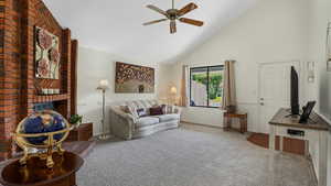 Carpeted living area featuring high vaulted ceiling, ceiling fan, and a brick fireplace