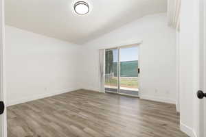 Unfurnished room featuring lofted ceiling and light wood-style flooring