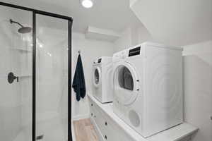 Laundry room featuring washing machine and dryer and light wood finished floors