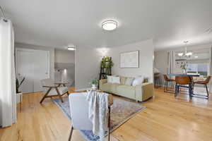 Living area featuring light wood-style floors and a chandelier