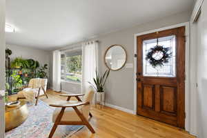 Foyer entrance with light wood-type flooring and baseboards