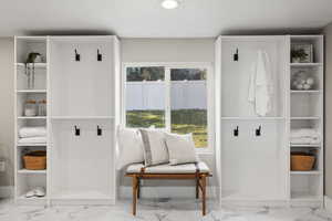 Mudroom featuring marble finish floors and a textured ceiling