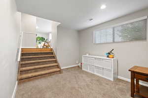 Staircase with carpet flooring and recessed lighting