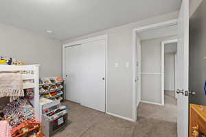 Carpeted bedroom with a closet and baseboards