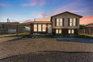 Split level home with a carport, concrete driveway, and brick siding