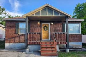 View of front of property with brick siding and covered porch