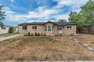 Ranch-style house with stucco siding and roof with shingles