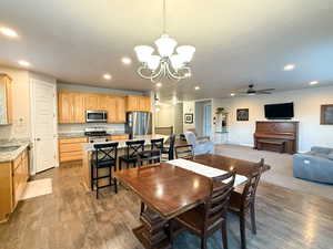Dining area featuring a chandelier, recessed lighting, wood finished floors, and a ceiling fan