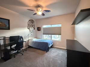 Bedroom with dark carpet,, and a ceiling fan