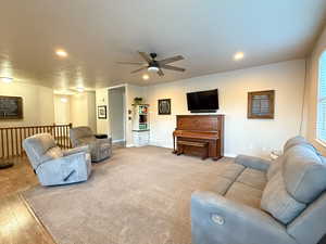 Living area with a ceiling fan, recessed lighting, and wood finished floors