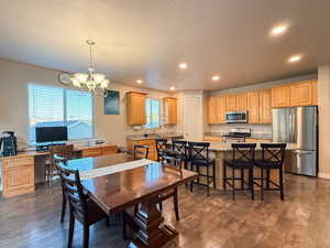 Dining space featuring dark wood-type flooring, a chandelier, recessed lighting, and a textured ceiling