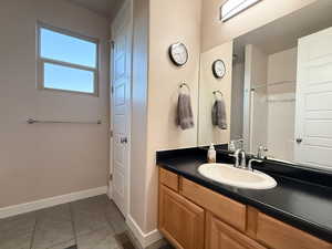 Full bathroom with tile patterned flooring, vanity, and a shower