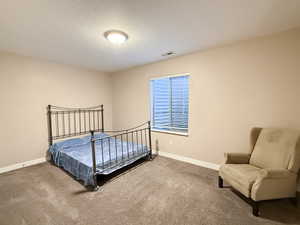 Bedroom with carpet and a textured ceiling