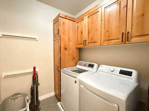 Laundry room with separate washer and dryer, cabinet space, and tile patterned flooring