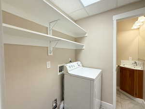 Laundry room with washer / clothes dryer and light tile patterned flooring
