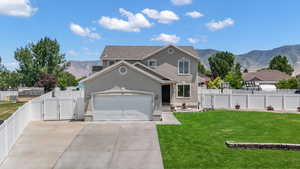 Traditional-style home with a gate, stucco siding, a mountain view, concrete driveway, and an attached garage