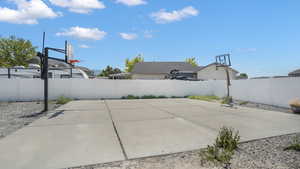 Fenced backyard featuring basketball court