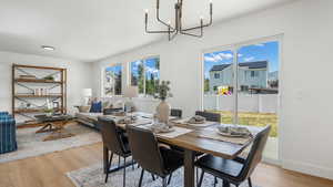 Dining space with a chandelier, light wood-style floors, and plenty of natural light