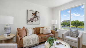 Living area with wood finished floors, ornamental molding, and plenty of natural light