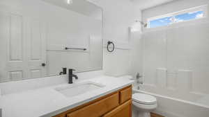 Bathroom featuring shower / washtub combination, vanity, and wainscoting