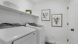 Laundry room featuring washer and clothes dryer and baseboards