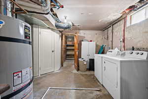 Laundry area featuring strapped water heater and washer and clothes dryer